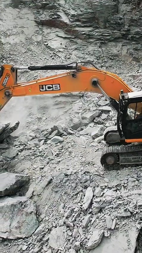 Excavator breaking rock at the mine face